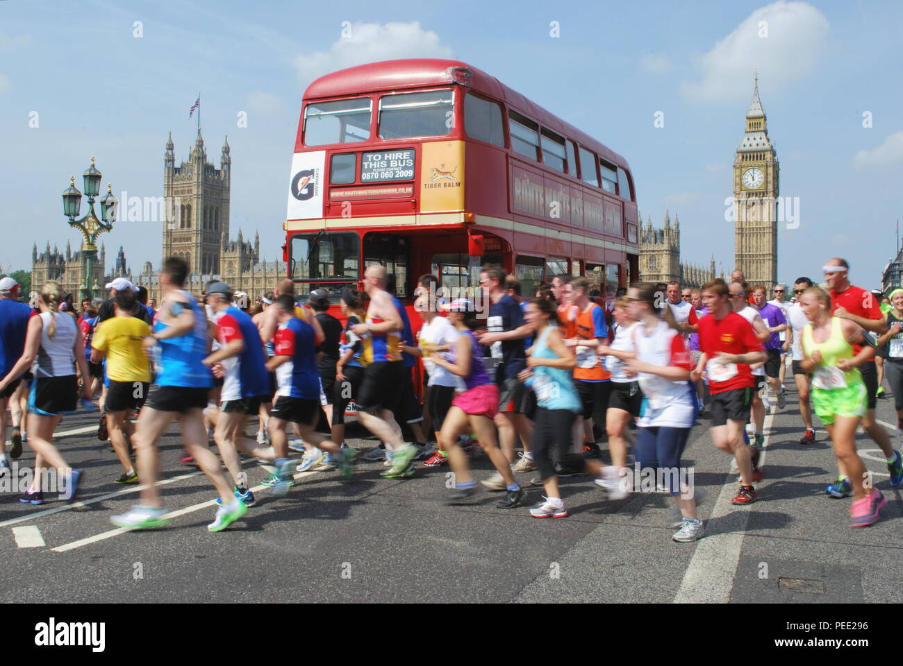 Runners passing red double-decker bus near Big Ben and Palace of Westminster in London Stock Photo