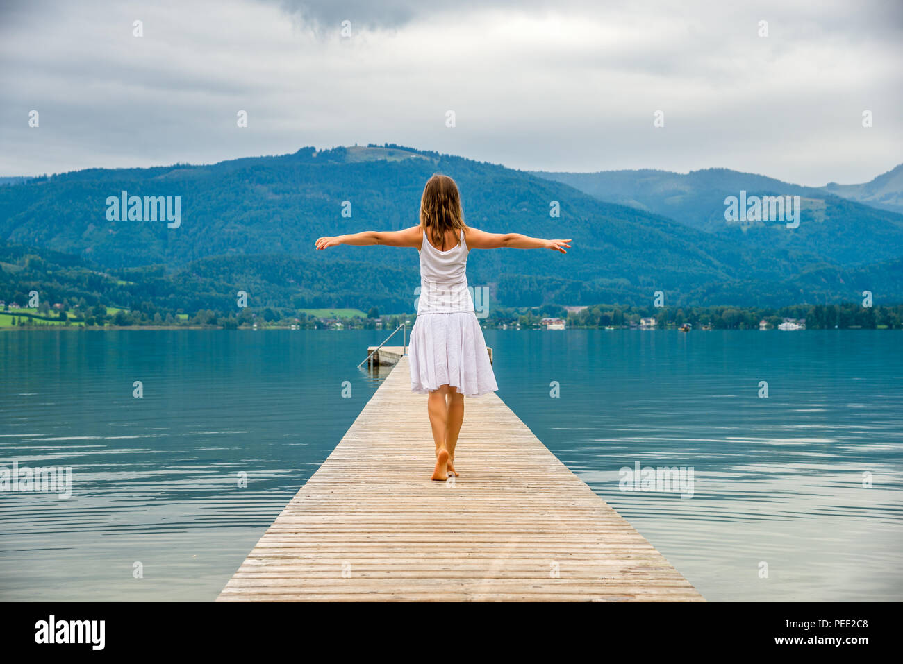 Woman walking on a pier. Lake Garda Italy Stock Photo