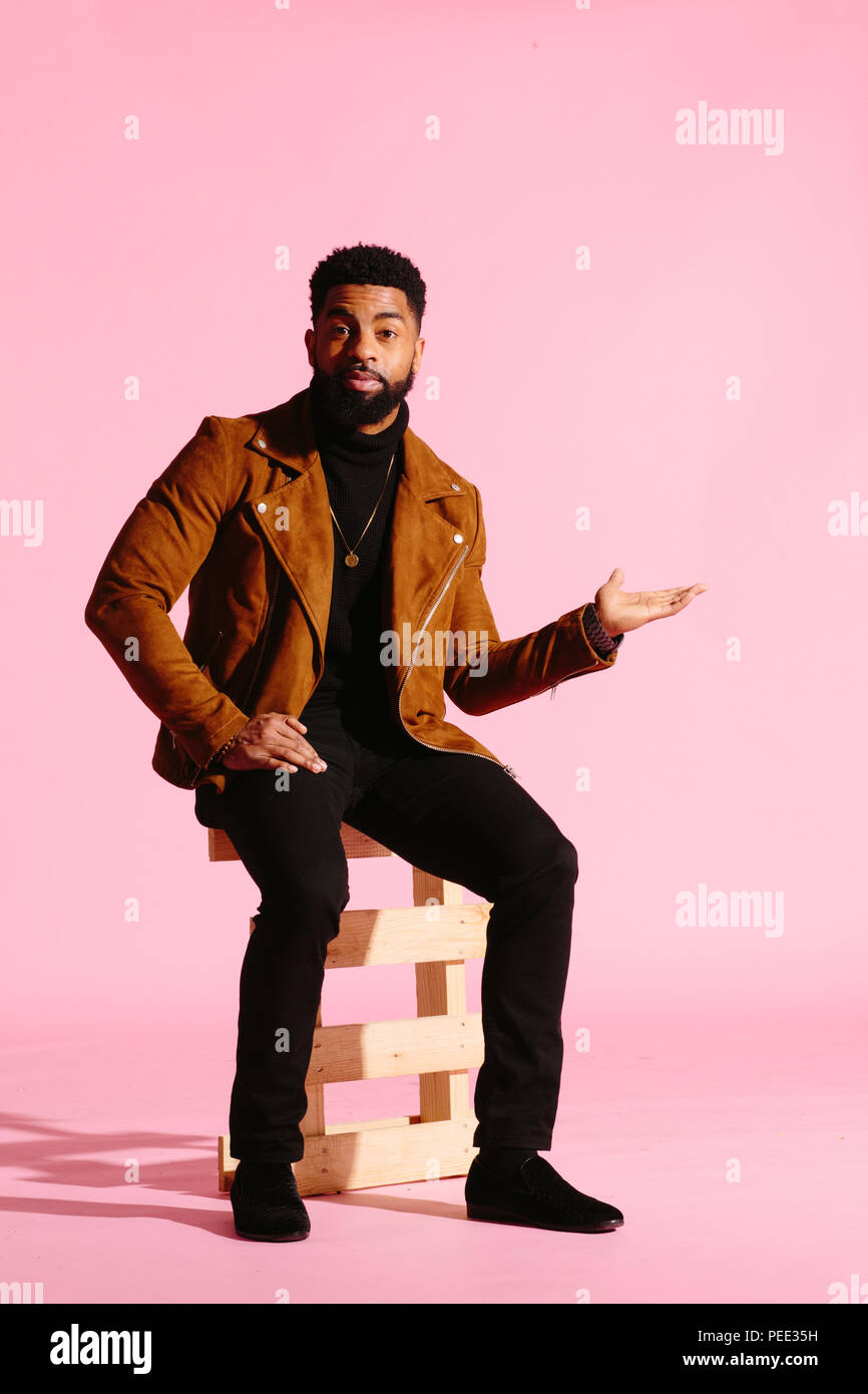 Stylish, handsome and cool African American man with beard, isolated on pink studio background Stock Photo