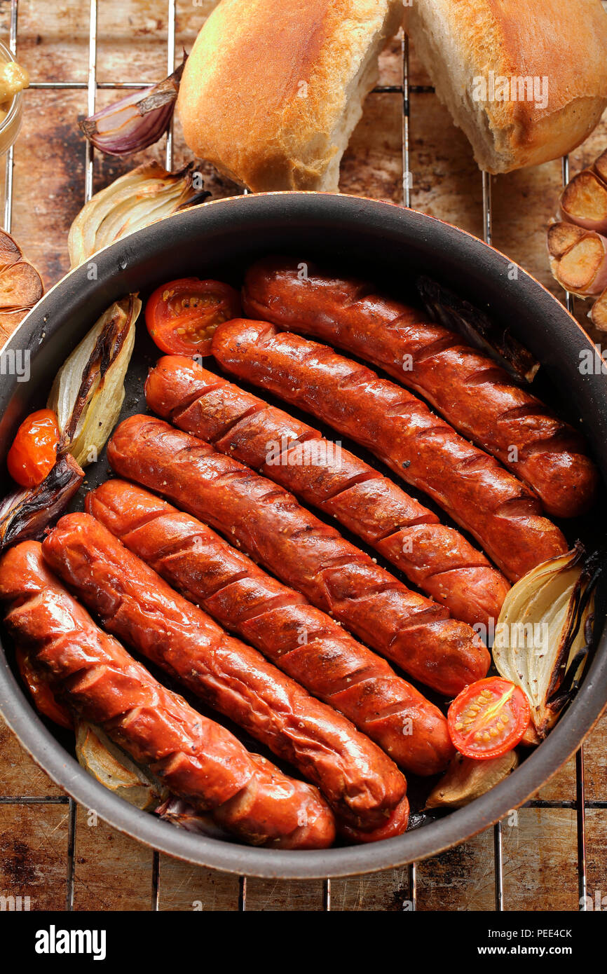 Grilled sausages in oven pan with garlic and onion Stock Photo Alamy