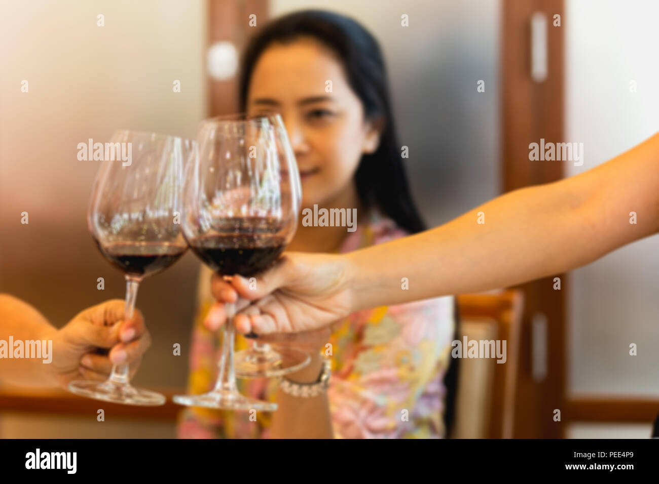 Group of friends raising a toast with glasses of red wine at family dinner Stock Photo