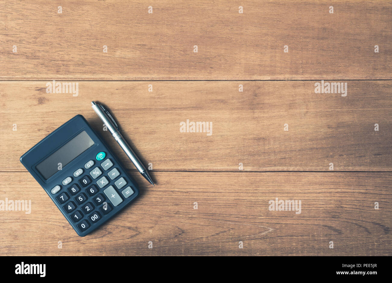 A Calculator And Pen On Wooden Background With Copy Space For
