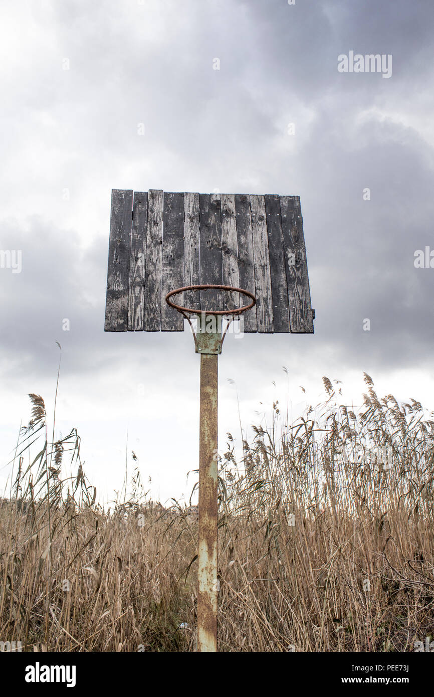 Old basketball backboard and basket. Deserted basketball backboard on a