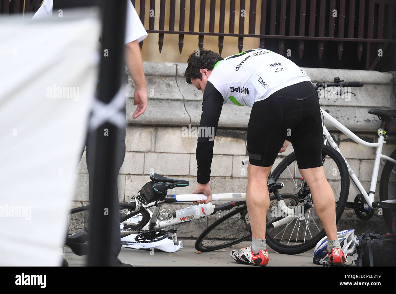 A cyclist returns to pick up his bike inside the cordon after a car crashed into security barriers outside the Houses of Parliament, Westminster, London. Stock Photo