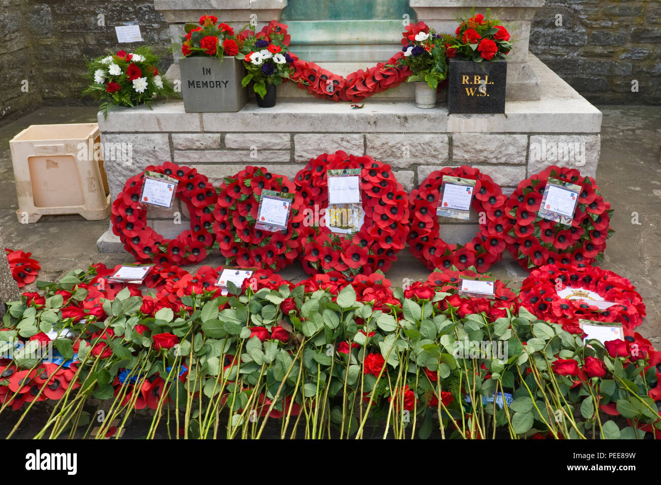 World War One commemorative event poppy wreaths & red roses laid around the War Memorial at Hay-on-Wye Powys Wales UK Stock Photo