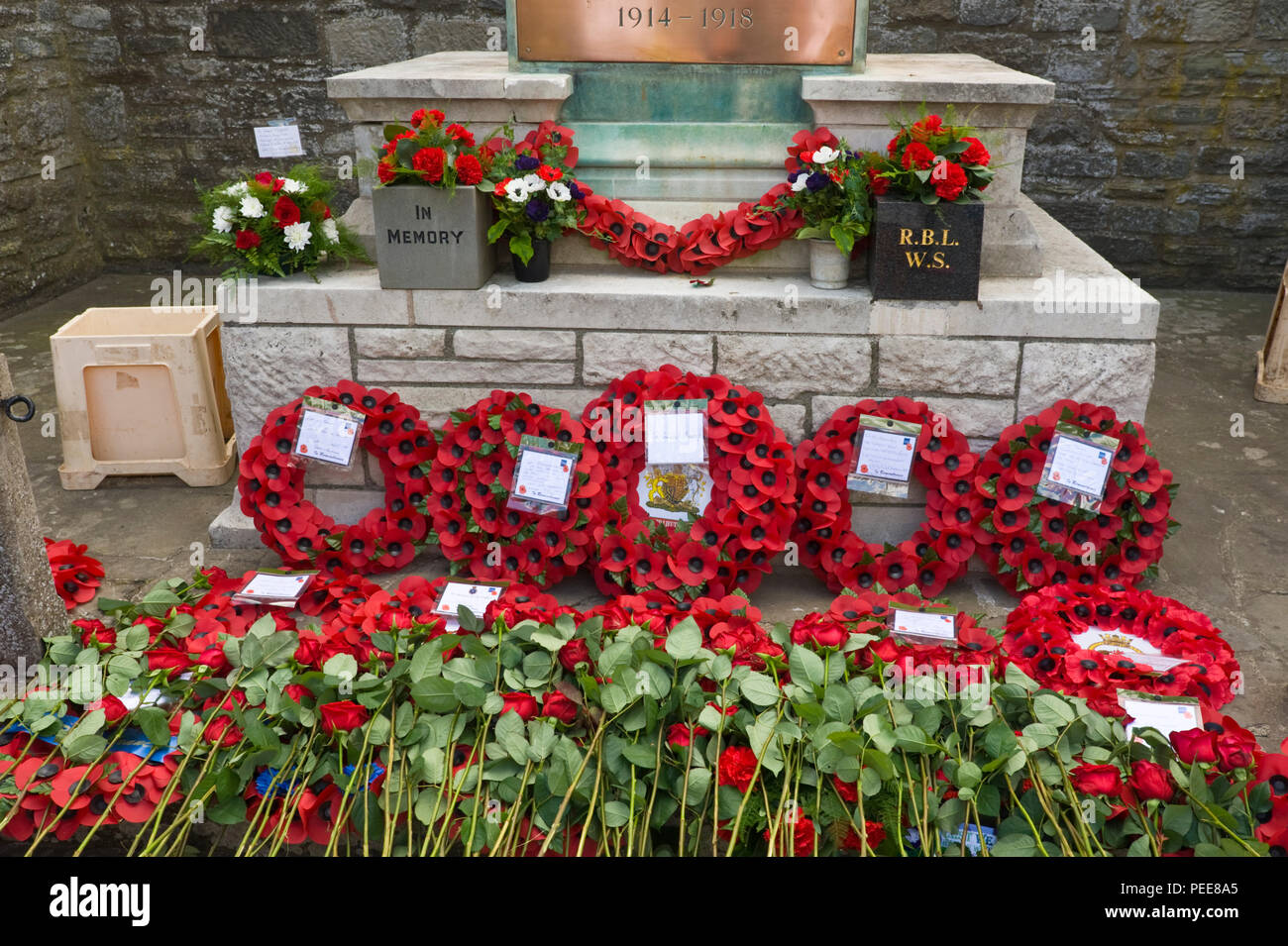 World War One commemorative event poppy wreaths & red roses laid around the War Memorial at Hay-on-Wye Powys Wales UK Stock Photo