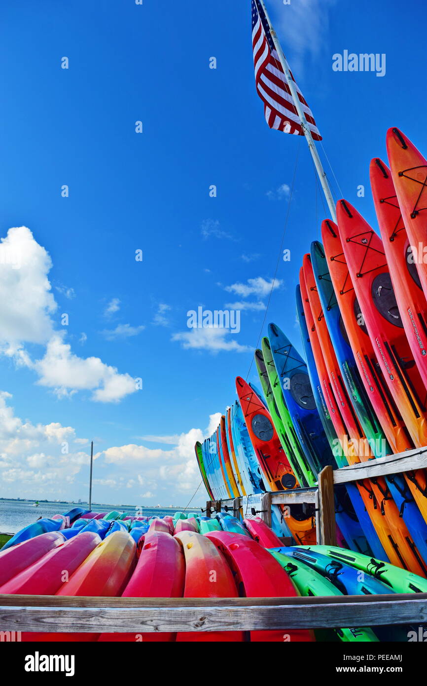Kayak and boat rental beach side with Tiki bar and man in background