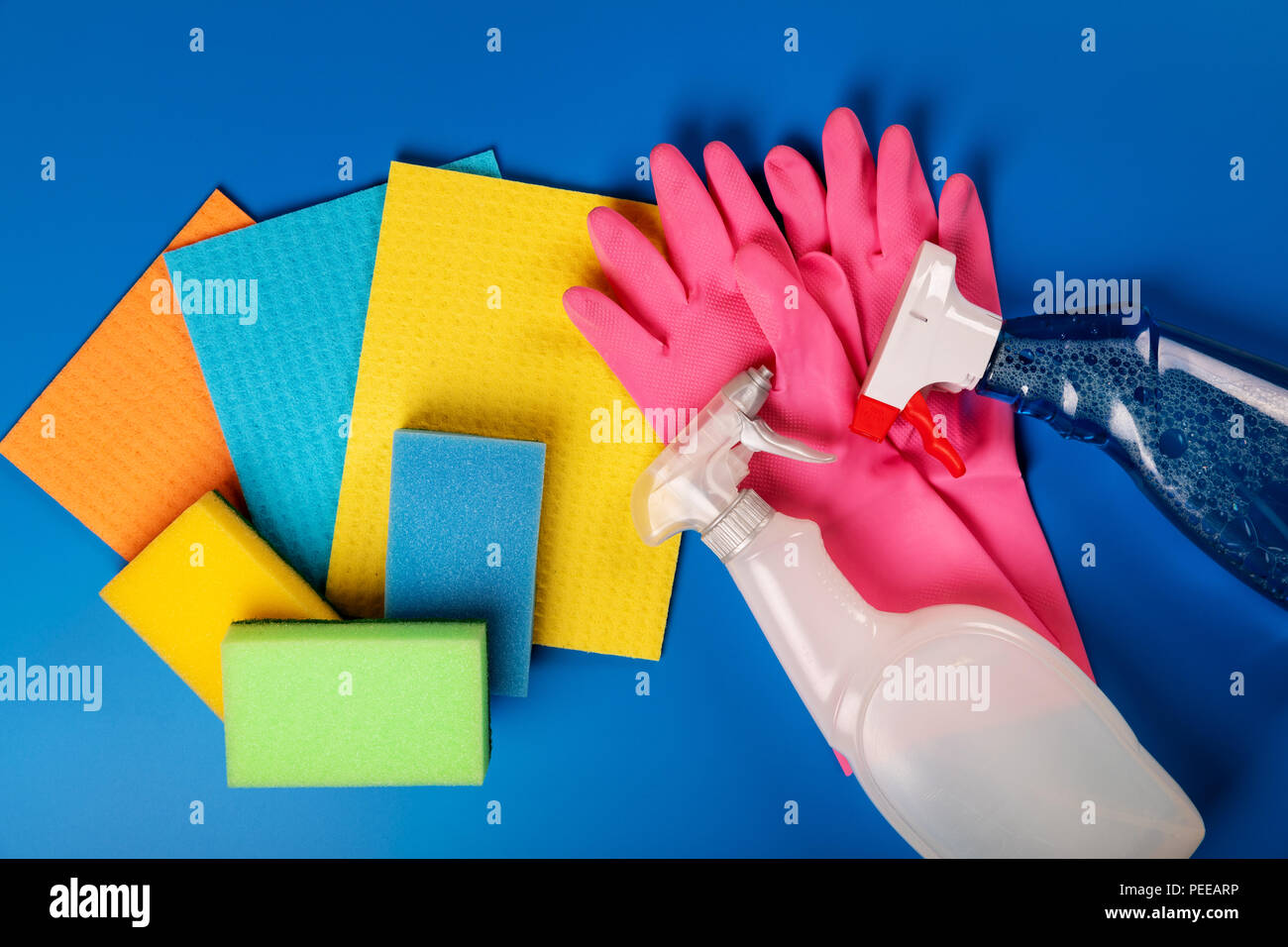 colorful cleaning equipment on blue background. top view Stock Photo