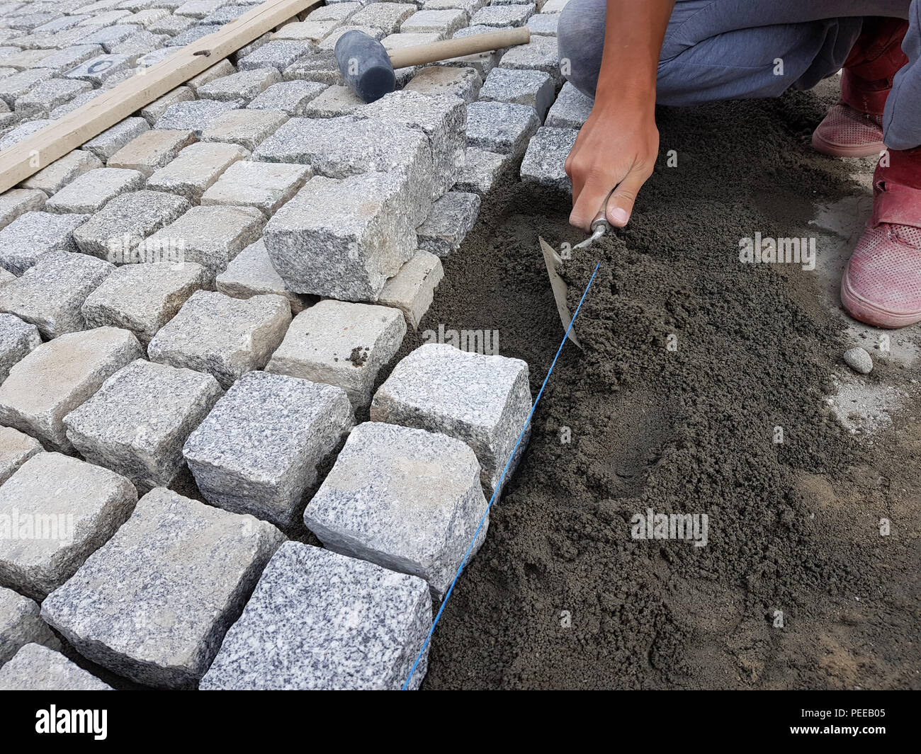 Construction worker making a pavement for renovating a street in an old city center Stock Photo