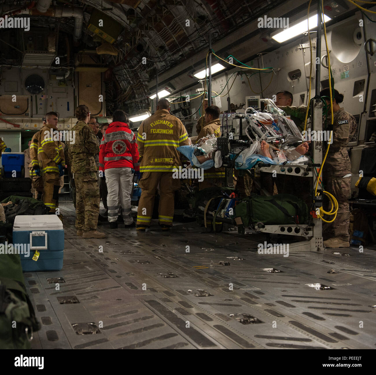 Firefighters and medical personnel standby to assist in the transport