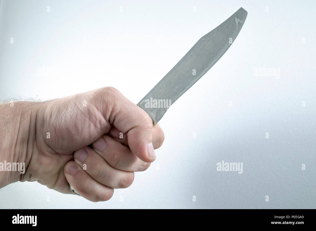 The hand holds a knife, the weapon of crime. Photo for a criminal article Stock Photo