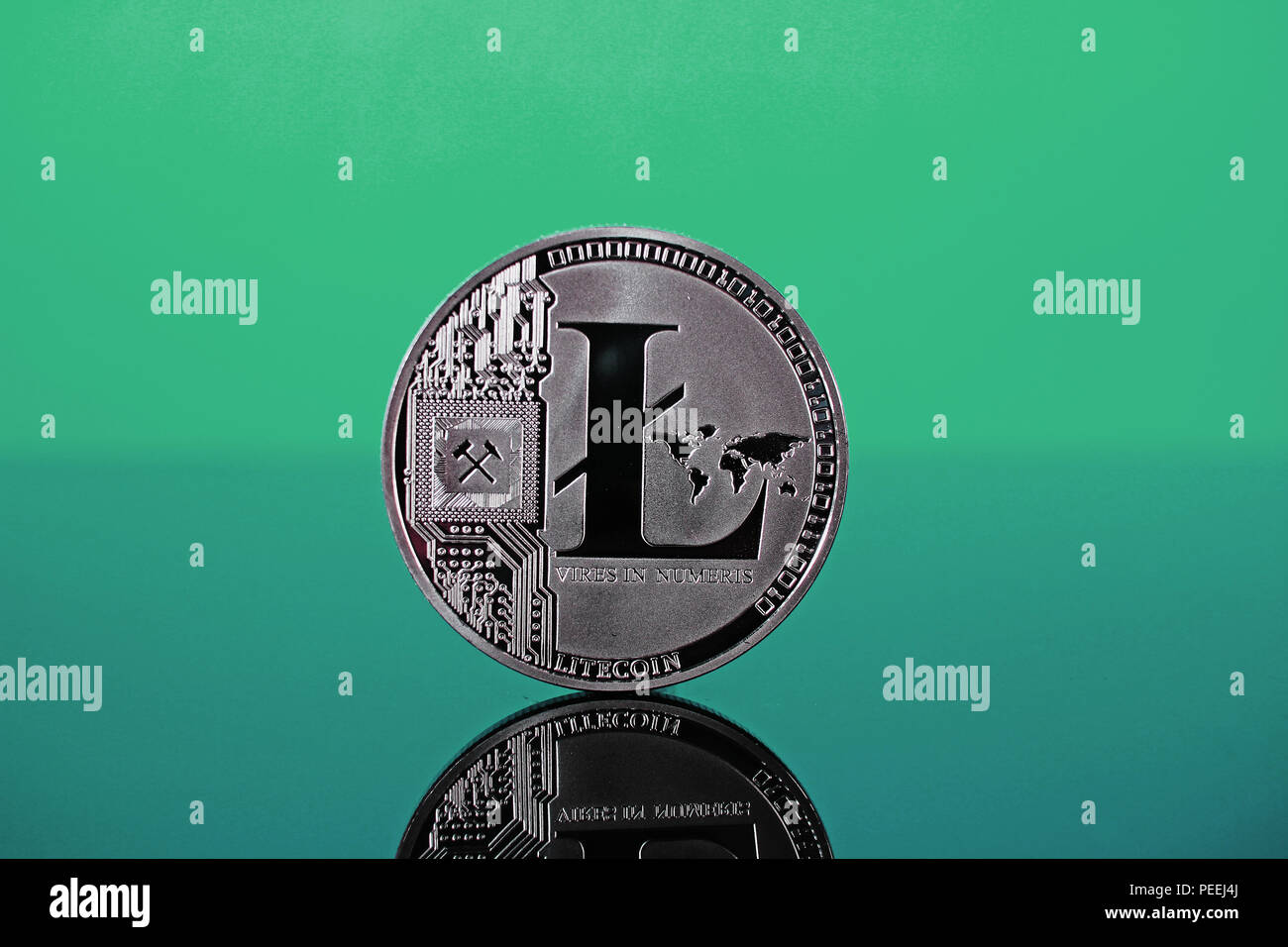 Litecoin crypto currency coin on reflective colorful background Stock Photo