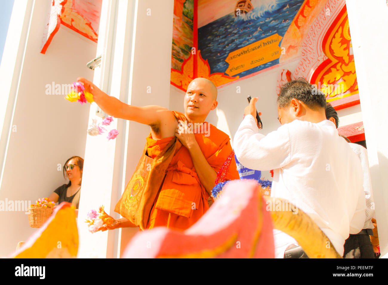 Ubon ratchathani, Thailand - Rookie monk and his relatives scattering donate alms flowers (wrapped money) at Thai temple. Stock Photo