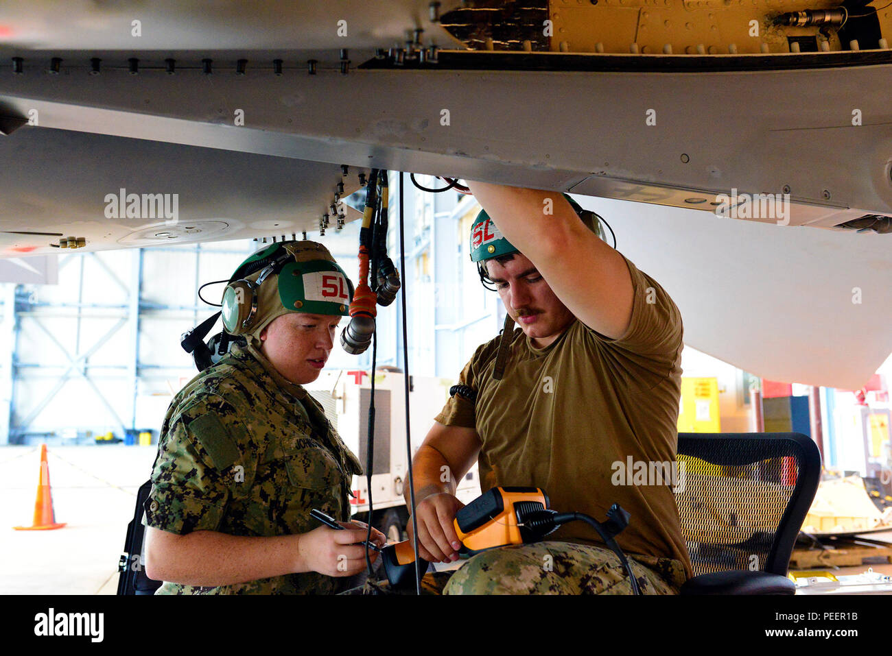 150812-N-OK605-002 MISAWA, Japan (Aug. 12, 2015) Aviation Structural Mechanic Equipment 2nd Class Alex Stults (right), from Springfield, Ill., and Aviation Structural Mechanic Equipment 3rd Class Karla Johnstun (left), from Rainier, Ore., both attached to the Scorpions of Electronic Attack Squadron (VAQ) 132, verify engine serial numbers on one of their EA18-G Growler fighter jets. VAQ-132 arrived at Misawa Air Base three weeks ago and will complete a six month deployment before returning to Naval Air Station Whidbey Island, Wash. (U.S. Navy Photo by Mass Communication Specialist 3rd Class Sam Stock Photo