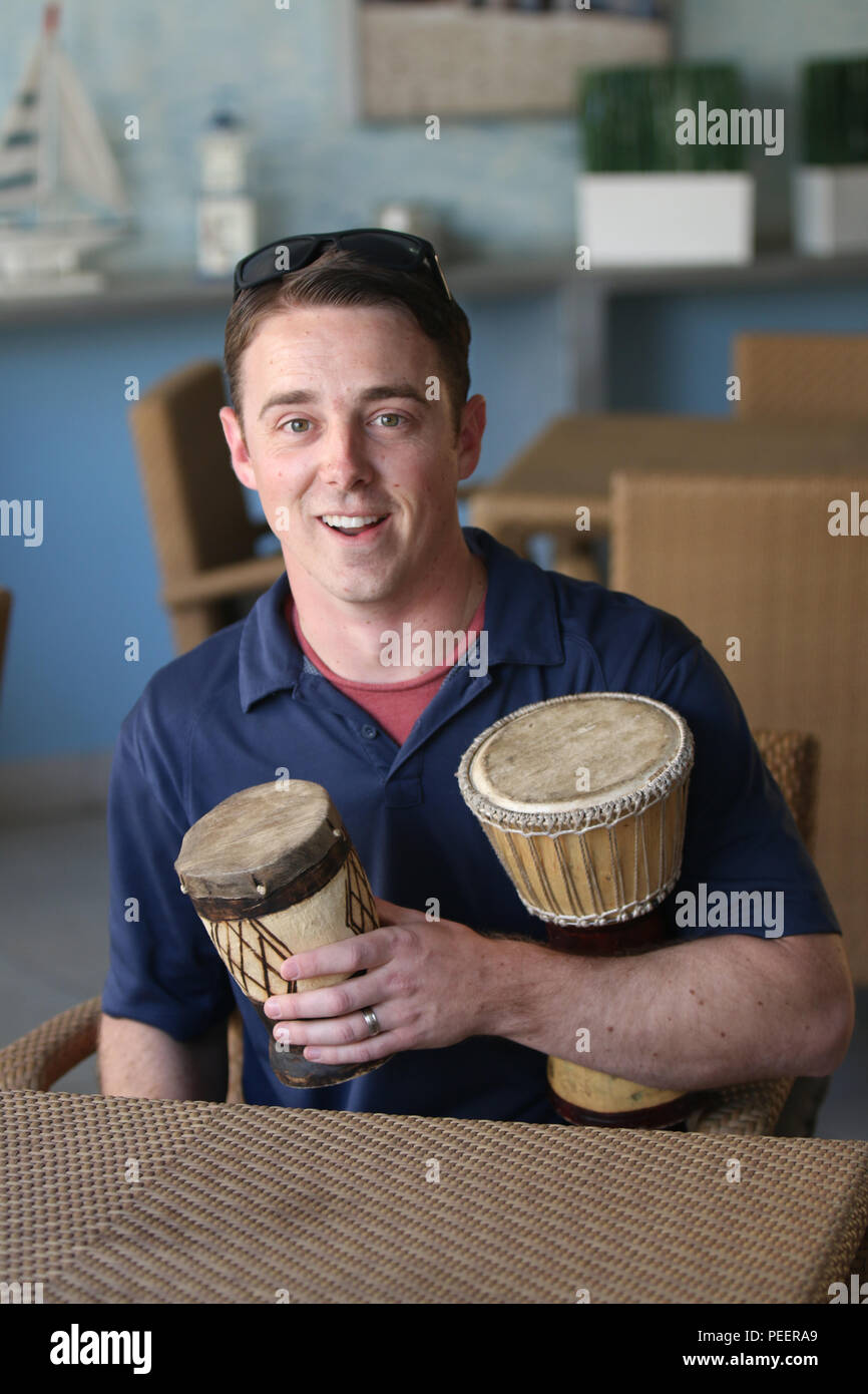 U.S. Air Force Staff Sgt. Brian Kimball, photographer for The Department of Defense News, displays his native drums purchased at a local market in Lusaka during cultural day events on Aug. 9, 2015. Southern Accord is one of four major exercises that U.S. Army Africa conducts each year for the two nations to train collectively using a United Nations standard. (U.S. Army Africa photo by Staff Sgt. Michael A. Simmons) Stock Photo
