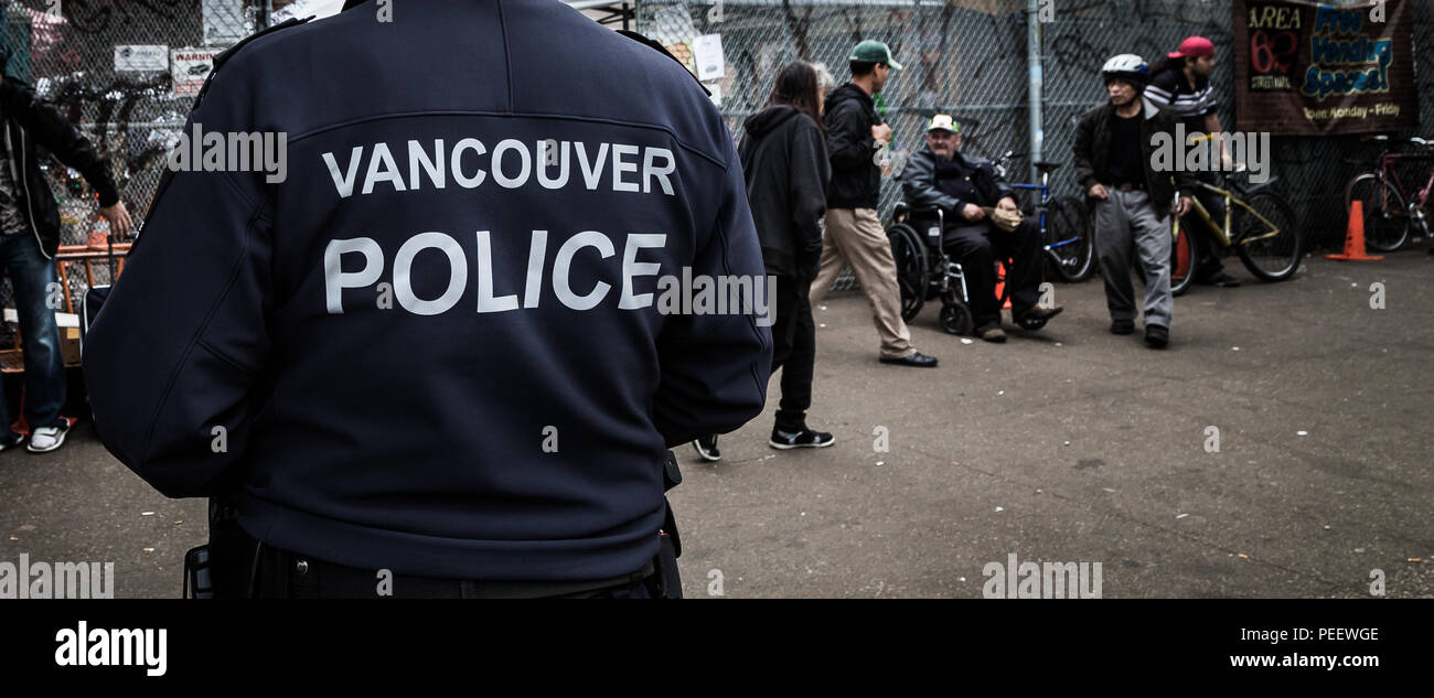 VANCOUVER, BC, CANADA - MAY 11, 2016: Vancouver Police Officer on patrol in an area of heavy drug use and poverty which is Vancouver's Downtown Eastside. Stock Photo