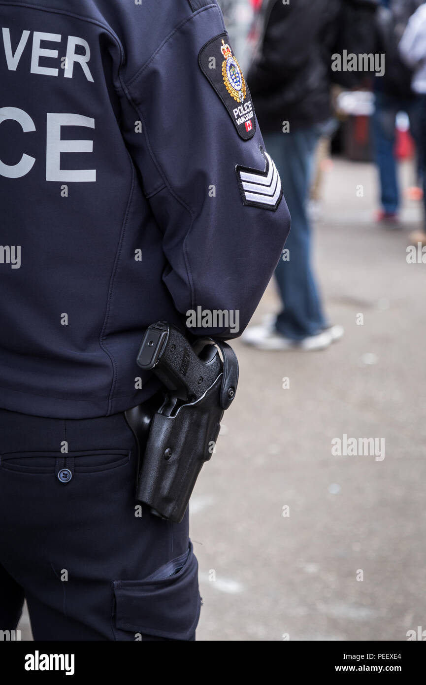 VANCOUVER, BC, CANADA - MAY 11, 2016: A close-up of a Vancouver Police Officer's gun and crest as they patrol the Downtown Eastside. Stock Photo