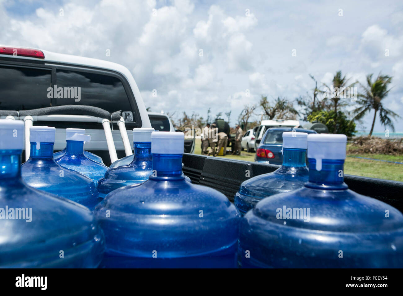 U.S. Marines with Combat Logistics Battalion 31, 31st Marine Expeditionary Unit, distribute water to local civilians as part of typhoon relief efforts in Saipan, Aug. 12, 2015. The 31st MEU and the ships of the Bonhomme Richard Amphibious Ready Group are assisting the Federal Emergency Management Agency with distributing emergency relief supplies to Saipan after the island was struck by Typhoon Soudelor Aug. 2-3. (U.S. Marine Corps photo by Lance Cpl. Brian Bekkala/Released) Stock Photo