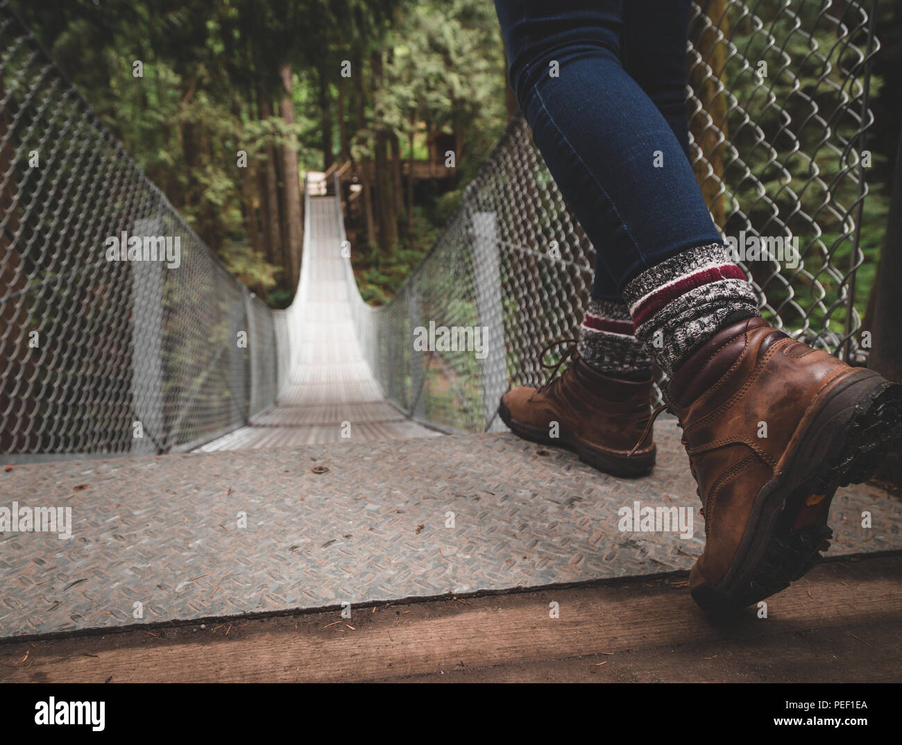 Hiking boots at the top of a suspension bridge in a forest Stock Photo -  Alamy
