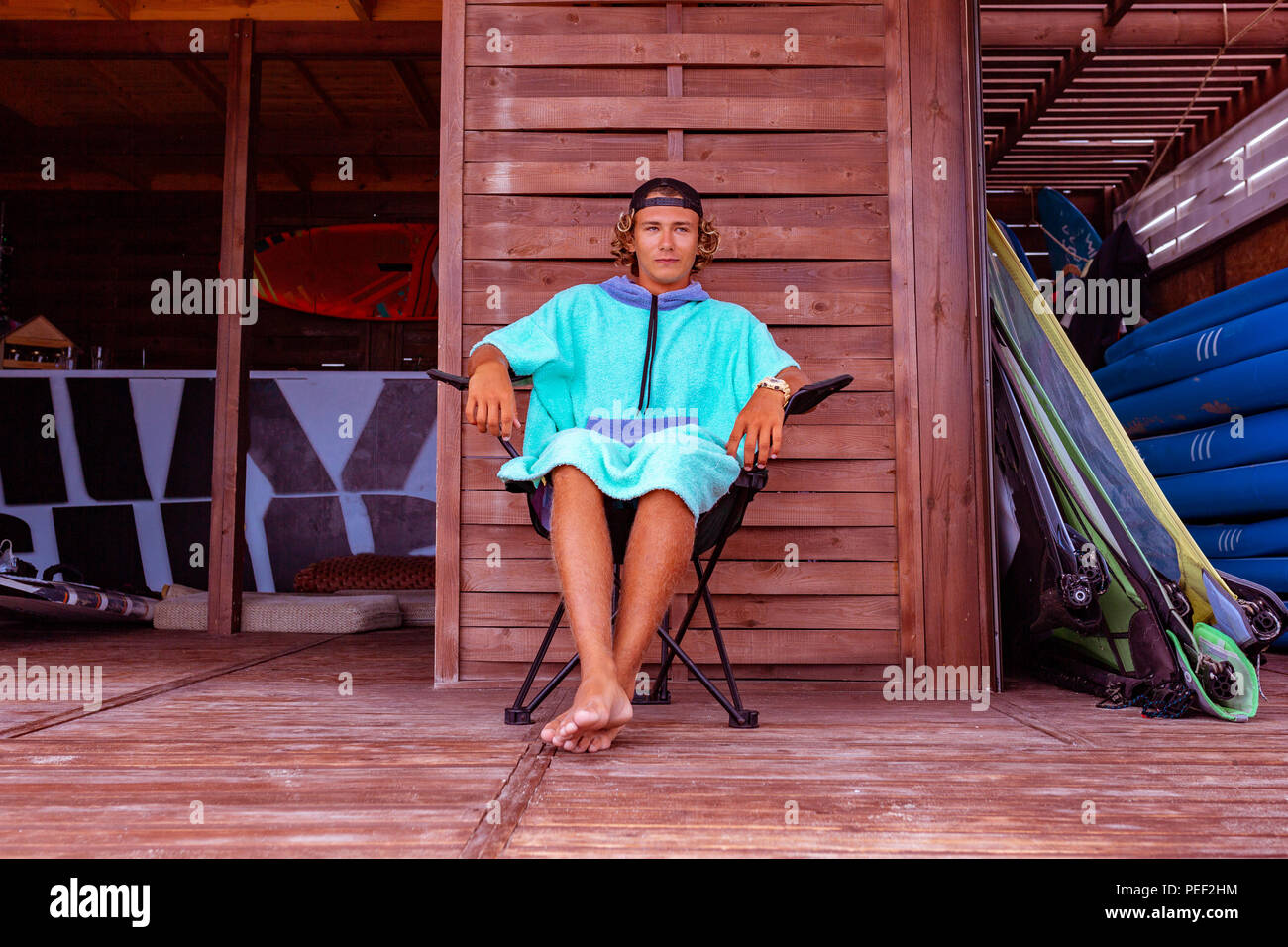 Young Attractive Guy Surfer Wearing A Bathrobe Is Sitting On The Terrace By The Sea Relaxing And Looking Out Into The Distance At Sea Stock Photo Alamy