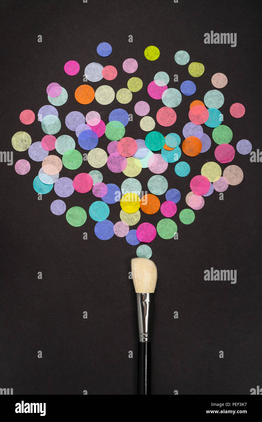 Makeup brush with colorful confetti on black background. Flat lay Stock Photo