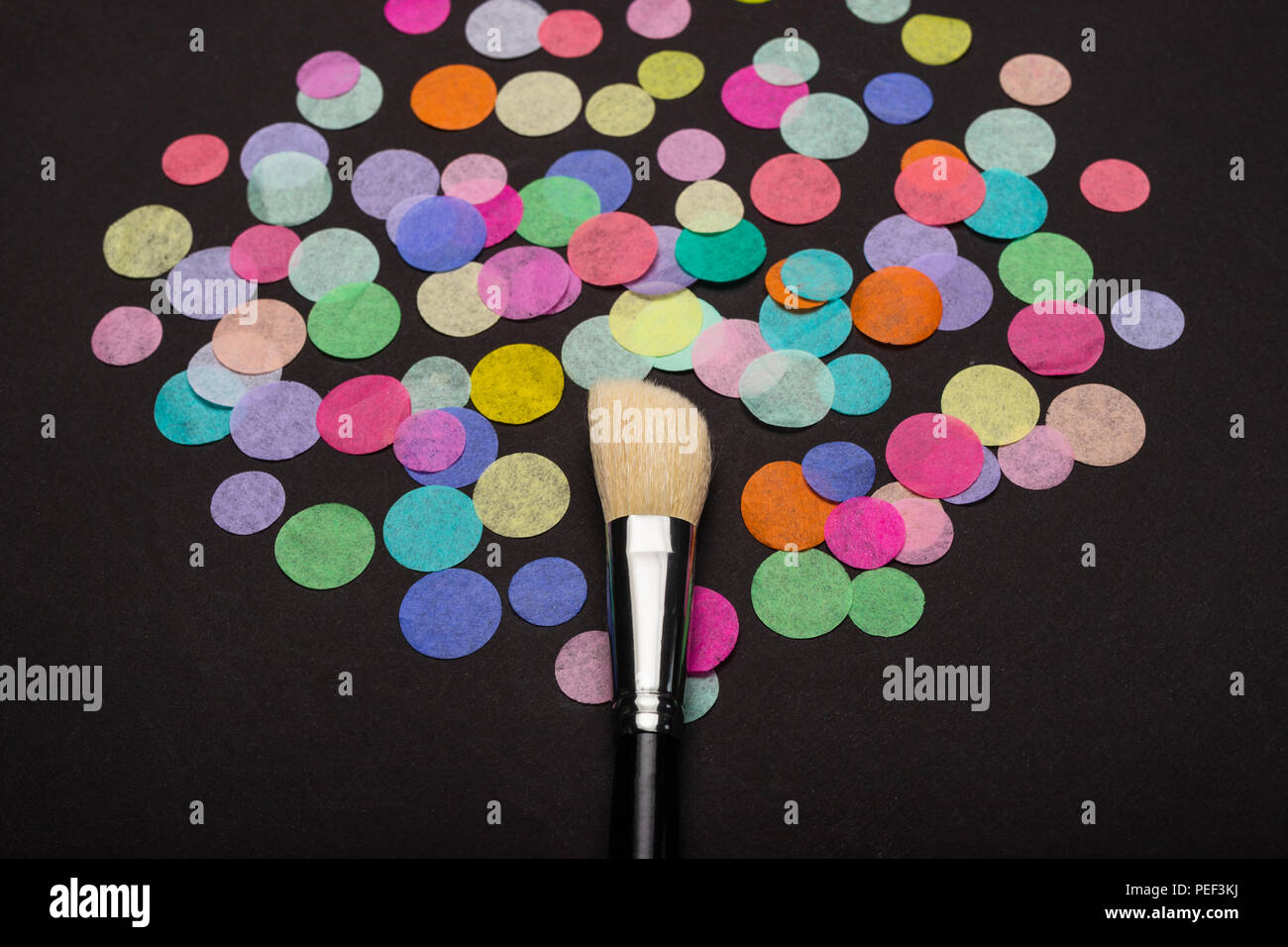 Close-up of makeup brush with colorful confetti Stock Photo