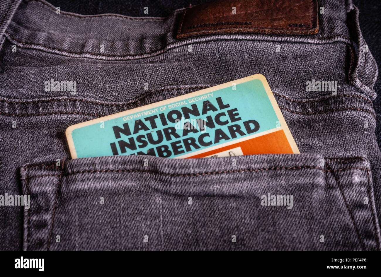 UK National Insurance number card sticking out of a trouser pocket Stock Photo