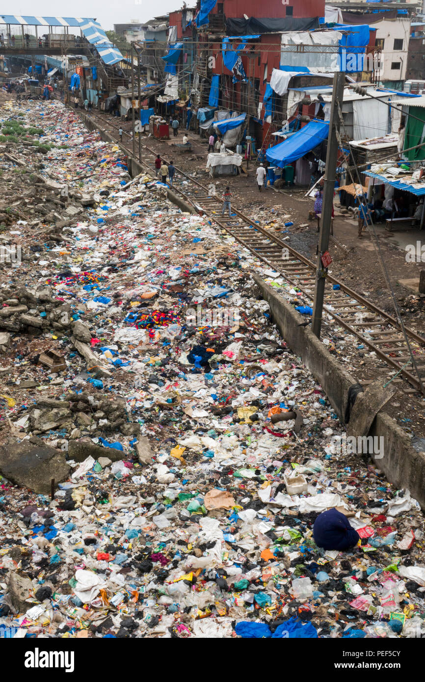 Piles of plastic trash next to train tracks and slum area at Bandra train station, Mumbai, India Stock Photo