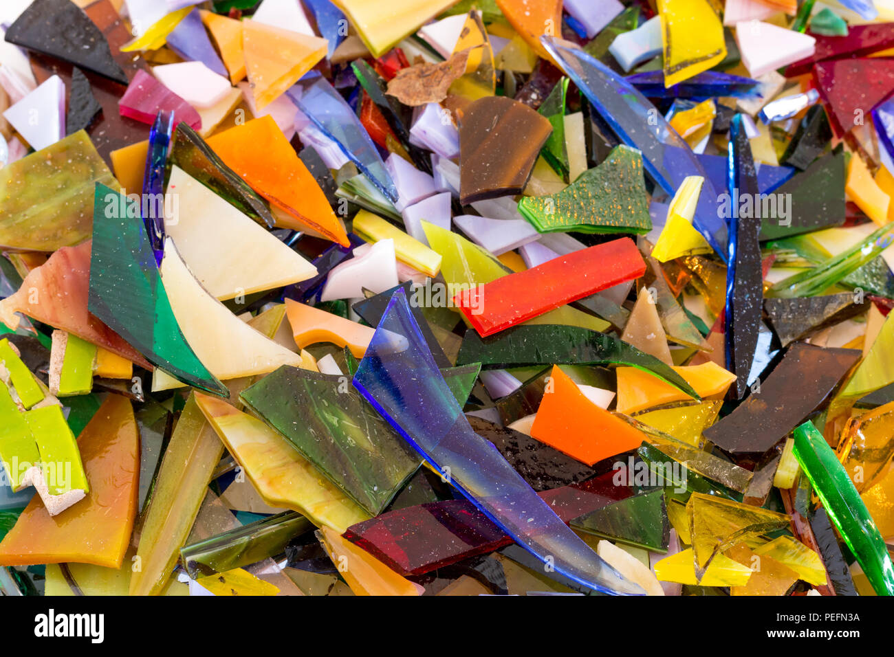 Closeup of bright multicolored stained glass chips in all shapes and sizes scattered and