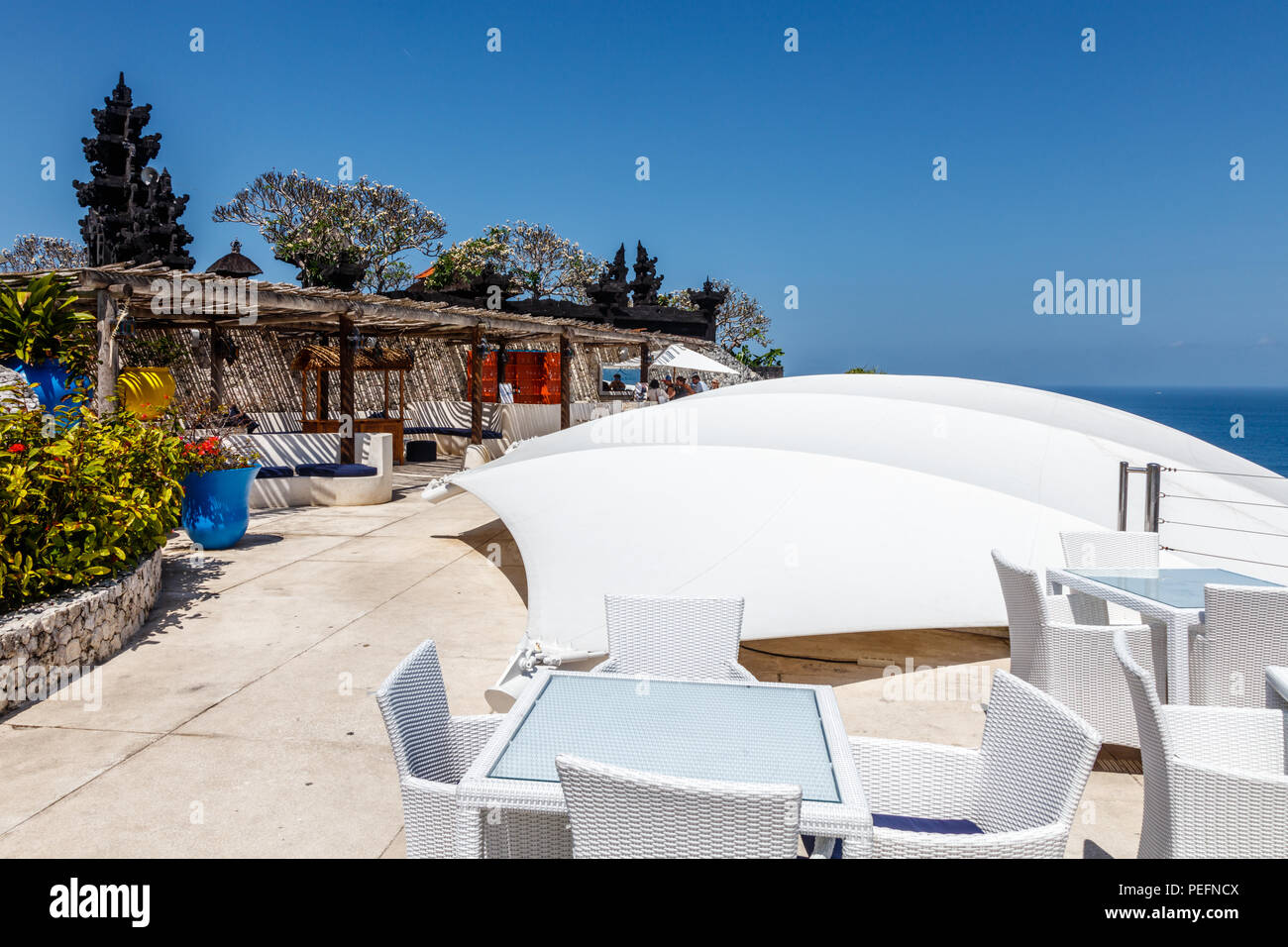 White tables and chairs at a outdoor cliff cafe with ocean view, Ungasan, Bali, Indonesia. Stock Photo