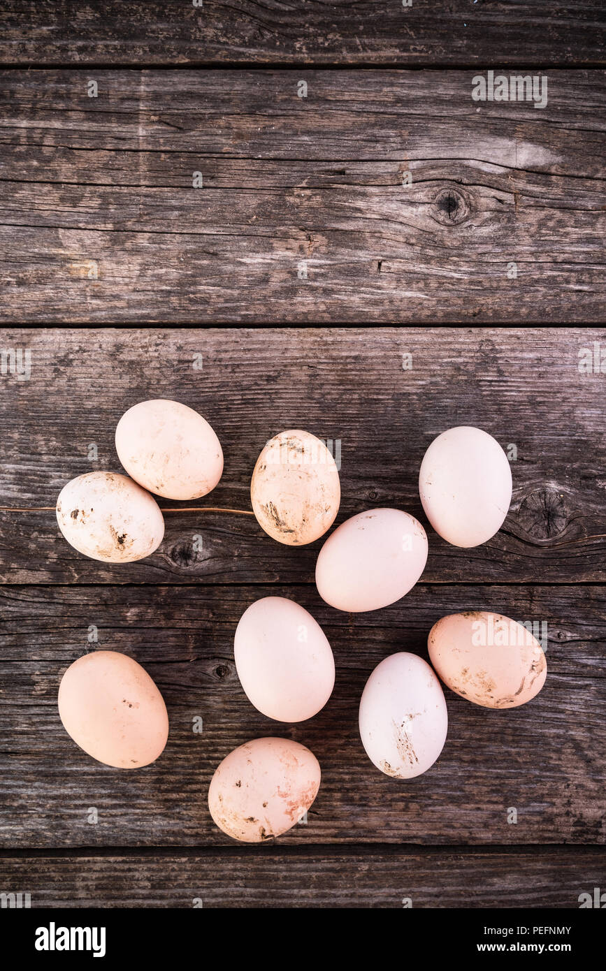 Dirty chicken eggs on wooden table, top view, with copy space for text