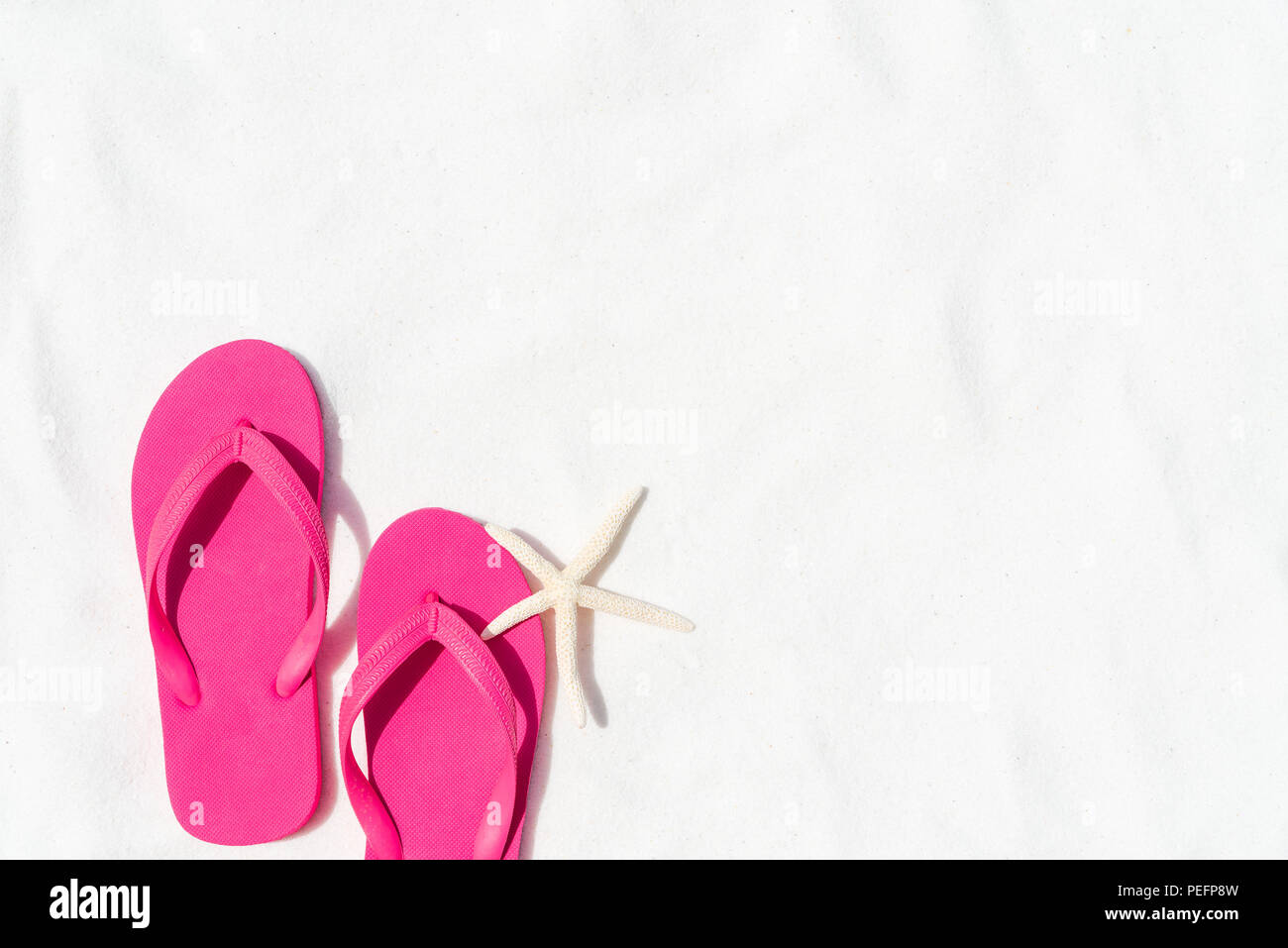 Pink flip flop put or step on on White sandy beach background with ...