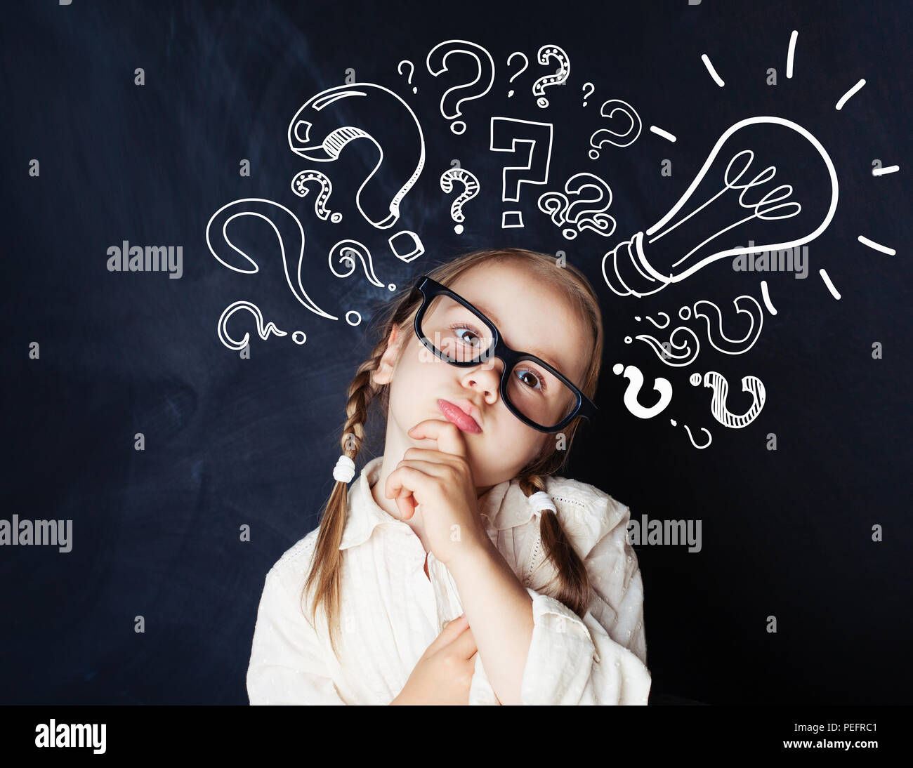 Elementary school student girl with question marks and lightbulb Stock Photo