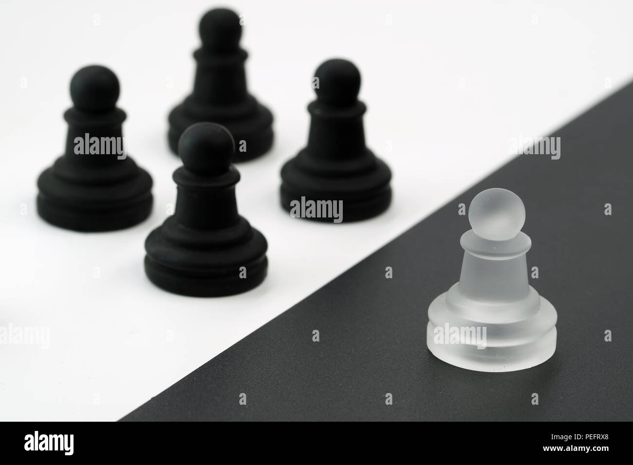 white figure against black figures. one against all. white vs. black Stock Photo