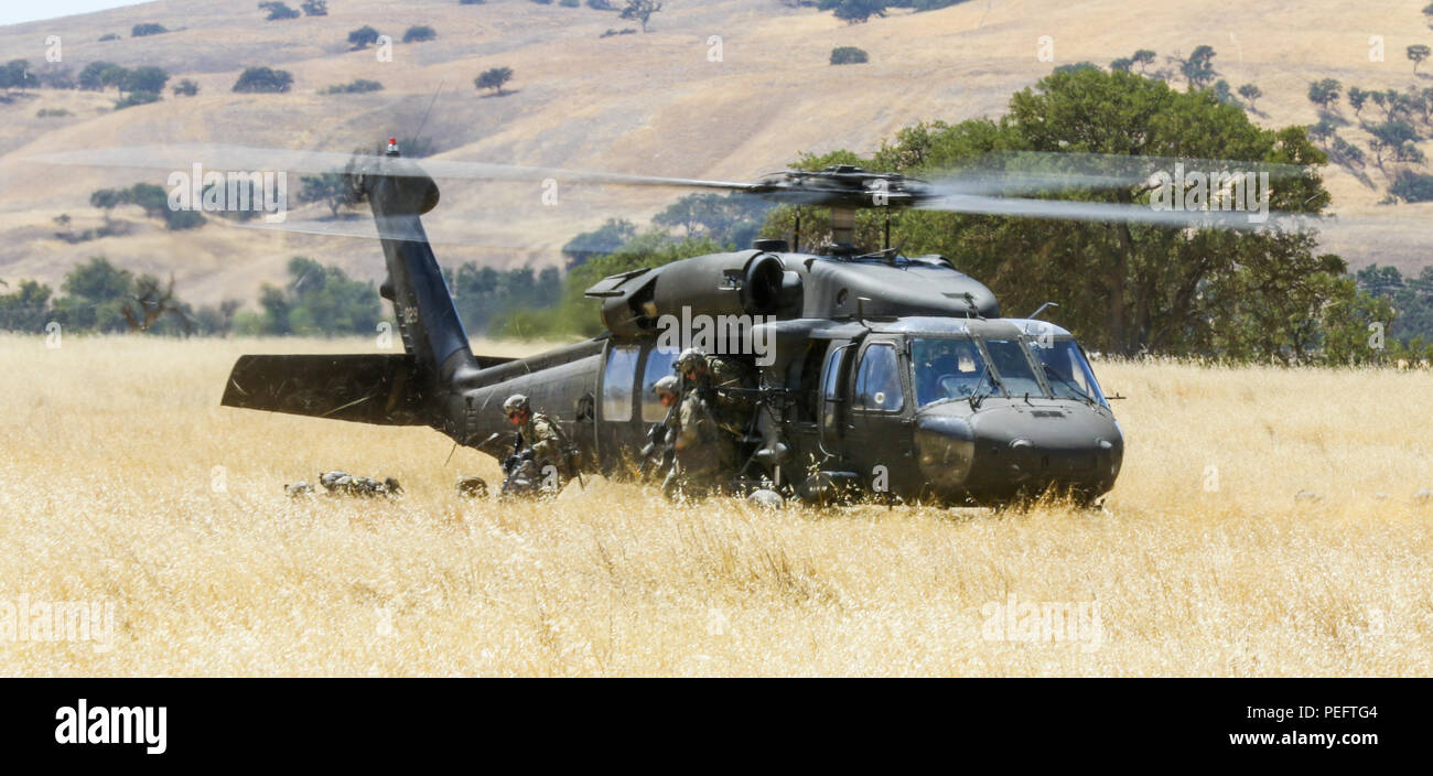 Soldiers with 1st Battalion, 186th Infantry Regiment, 41st Infantry Brigade Combat Team, Oregon Army National Guard rush out of the UH-60 Black Hawk helicopter to secure the landing zone while conducting air assault training August 3, 2018 during a field training exercise known as eXportable Combat Training Capability (XCTC) at Camp Roberts, Calif. The exercise is a brigade-level field training exercise designed to certify platoon proficiency across the brigade in coordination with First Army. The XCTC program brings full training resource packages to National Guard and Active Duty Army bases  Stock Photo