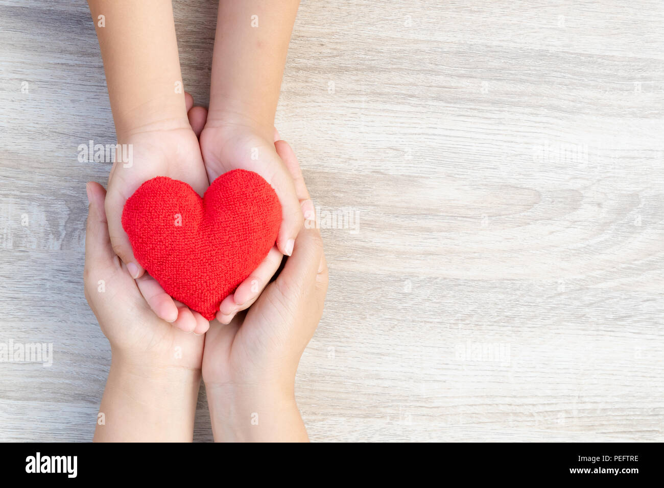Health care, love, organ donation, family insurance and CSR concept. adult and child hands holding handmade red heart on wooden background Stock Photo - Alamy Health care, love, organ donation, family insurance and CSR concept. adult and child hands holding handmade red heart on wooden background Stock Photo - Alamy