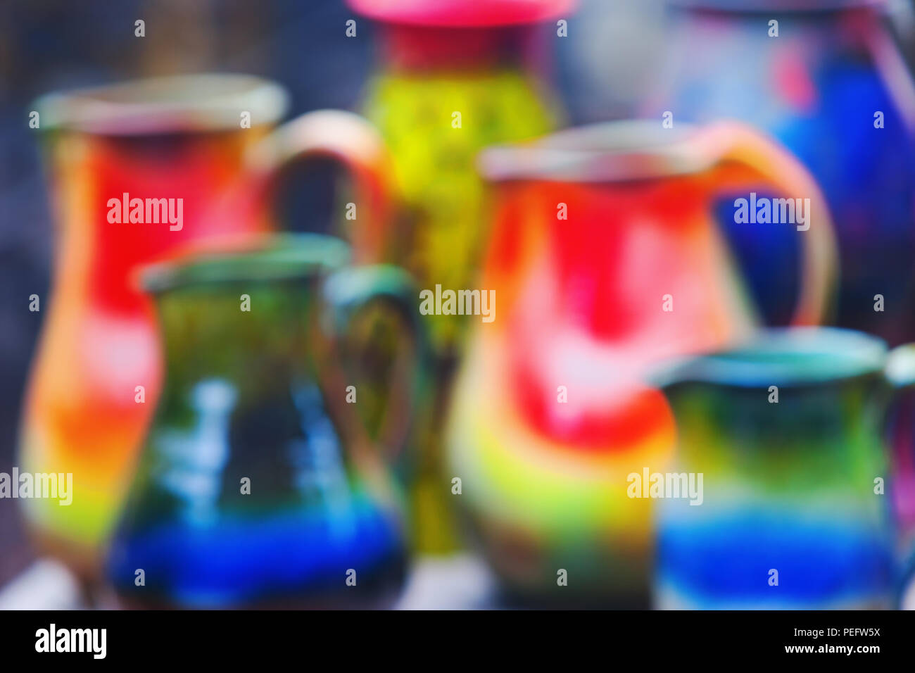Some bright multi-colored earthenware jugs for water. Blurry Stock Photo