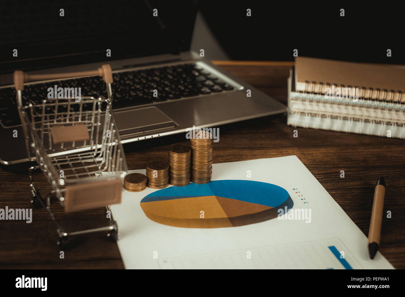 Step of coins stacks with trolley and notebook laptop computer and ...