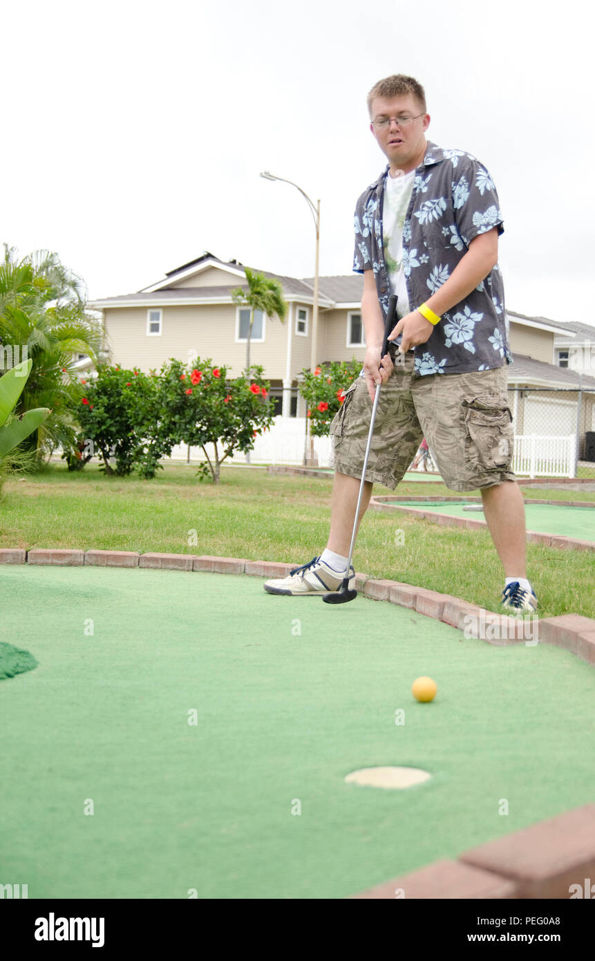 U.S. Army Spc. Christopher Strand, 25th Infantry Division, and Albany, Ore., native, putts his ball at Tiki Island near the Kaneohe Klipper Golf Course during Klipper Summer Bash 7, Aug. 15, 2015. Marine Corps Community Services Hawaii hosted Klipper Summer Bash 7 at the Kaneohe Klipper Golf Course with a putting and long drive contest, activities, food and entertainment for active duty service members and their families. There were balloon makers, bounce houses, bumper boat rides, mini golf and mini amusement park rides for the children. Live music included Ikena & The Pocket Band, Crimson Ap Stock Photo