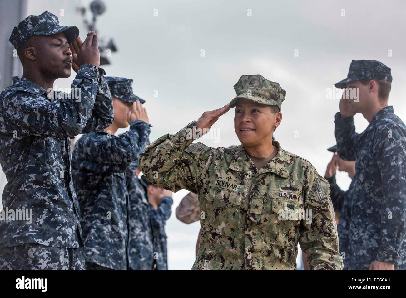 U.S. Navy sailors from the USS Ashland (LSD 48) render a salute to Rear Adm. Bette Bolivar, the commander of U.S. Naval Forces Marianas, as she boards the ship in Saipan, Aug. 9, 2015. The 31st Marine Expeditionary Unit and the ships of the Bonhomme Richard Amphibious Ready Group are assisting the Federal Emergency Management Agency with distributing emergency relief supplies to Saipan after the island was struck by Typhoon Soudelor Aug. 2-3. (U.S. Marine Corps photo by Lance Cpl. Brian Bekkala/Released) Stock Photo