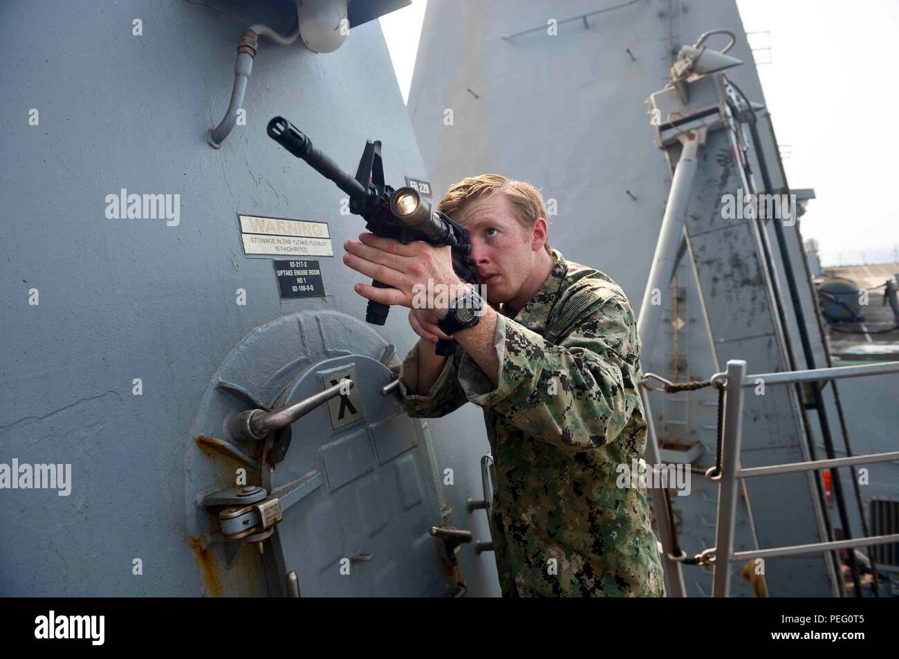 150815-N-ZF498-047 U.S. 5TH FLEET AREA OF OPERATIONS (Aug. 15, 2015) – Intelligence Specialist 3rd Class Jeff Gabelmann, from Fort Pierce, Fla., conducts tactical clearing training as part of the visit, board, search and seizure (VBSS) team aboard the guided-missile destroyer USS Forrest Sherman (DDG 98). Forrest Sherman is deployed to the U.S. 5th Fleet area of operations as part of Theodore Roosevelt Carrier Strike Group supporting Operation Inherent Resolve, strike operations in Iraq and Syria as directed, maritime security operations and theater security cooperation efforts in the region.  Stock Photo