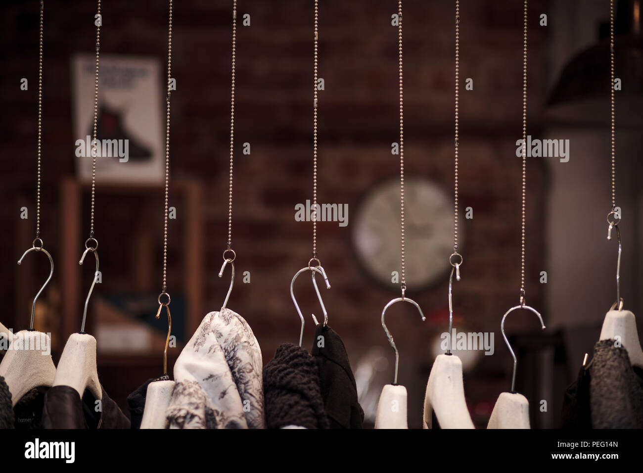 Many clothes hanger on chains with dark background in a shop Stock