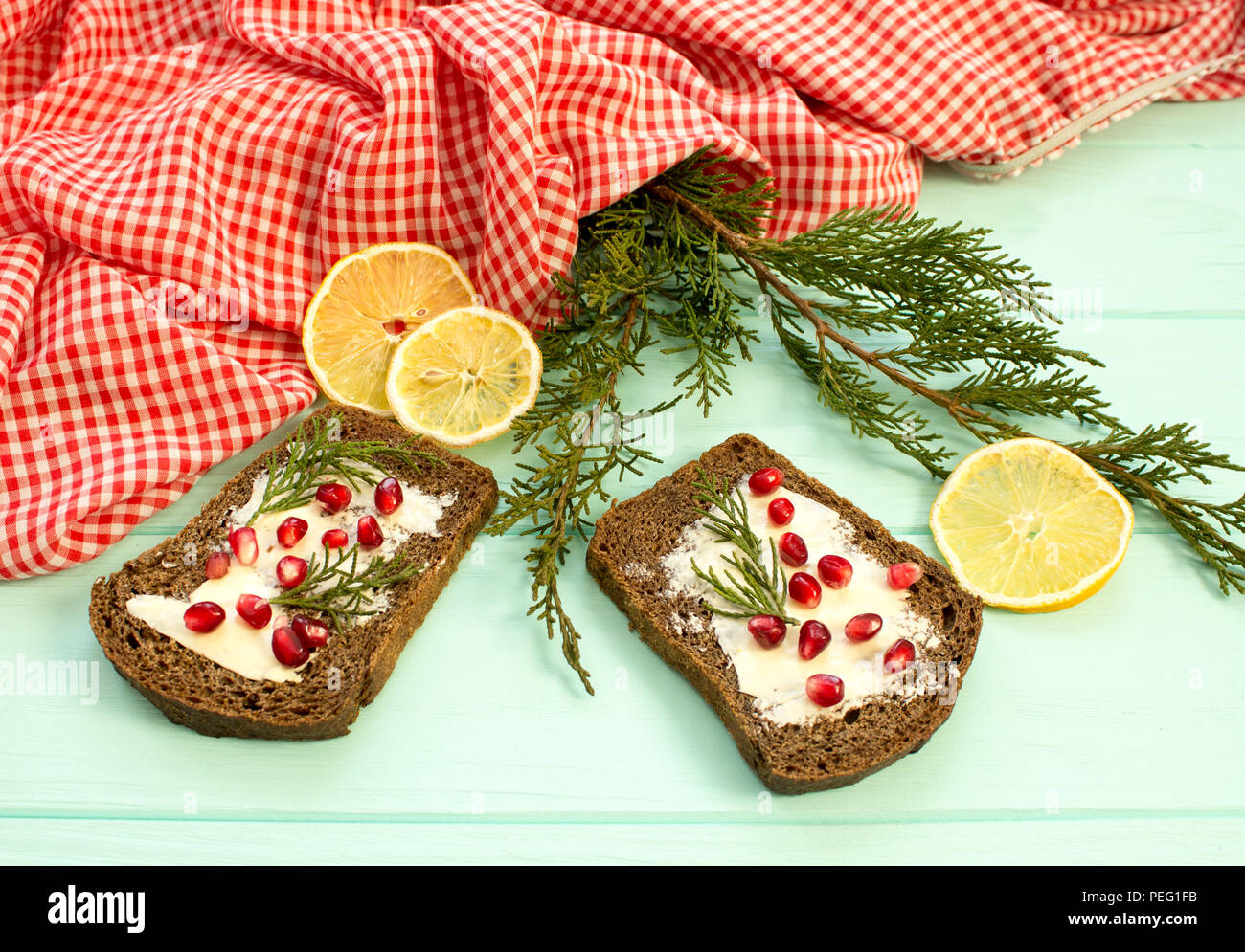 Black Bread With Grenades Berries On Turquoise Wooden Background