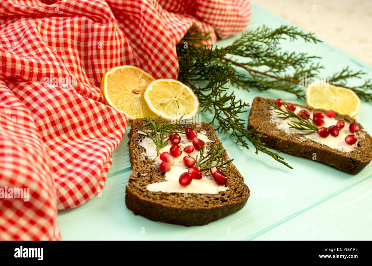 Black Bread With Grenades Berries On Turquoise Wooden Background