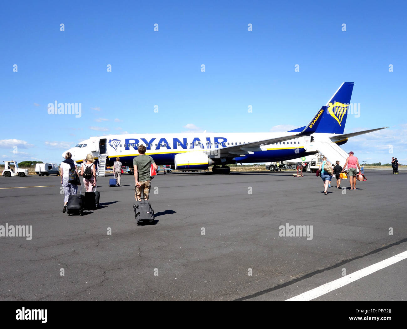 Passengers walking across the tarmac towards their homeward flight on a Ryanair plane Stock Photo