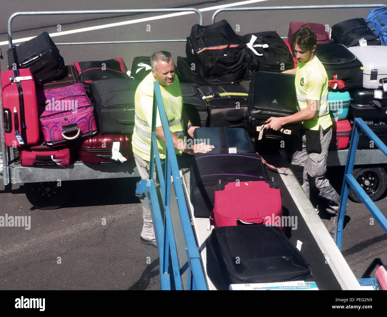 Baggage being put on a conveyor into a plane at Beziers Cap d'Agde