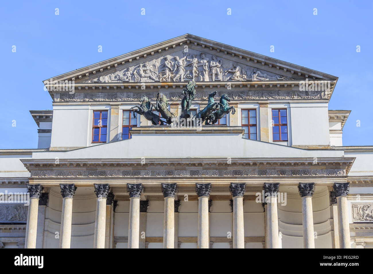 A fragment of classicism facade over entrance to Warsaw Grand Theater. Tympanum is sculpture of Anakreont & three muse chisels by Tomasz Accardi Stock Photo