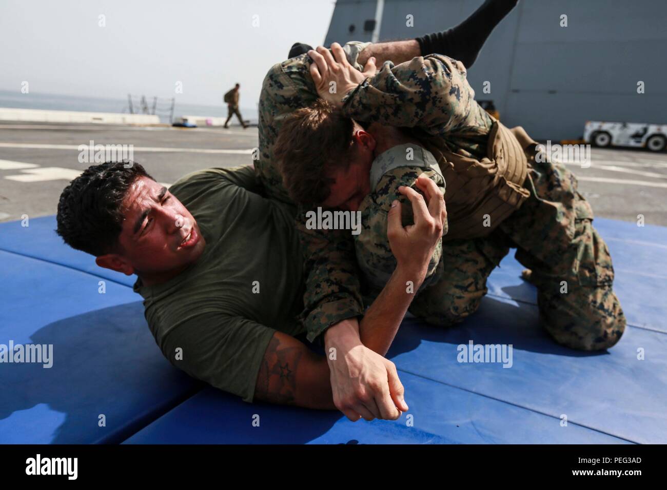 GULF OF ADEN (Aug. 18, 2015) U.S. Marine Sgt. Joshua Ruiz, left, grapples with Lance Cpl. Joshua D. Hancock during a Marine Corps martial arts program green belt course aboard the amphibious transport dock ship USS Anchorage (LPD 23). Ruiz is an operations clerk and Hancock is an armorer with Combat Logistics Battalion 15, 15th Marine Expeditionary Unit.  The 15th MEU is embarked on the Essex Amphibious Ready Group and deployed in support of maritime security operations and theater security cooperation efforts in the U.S. 5th Fleet area of operations. (U.S. Marine Corps photo by Sgt. Steve H.  Stock Photo