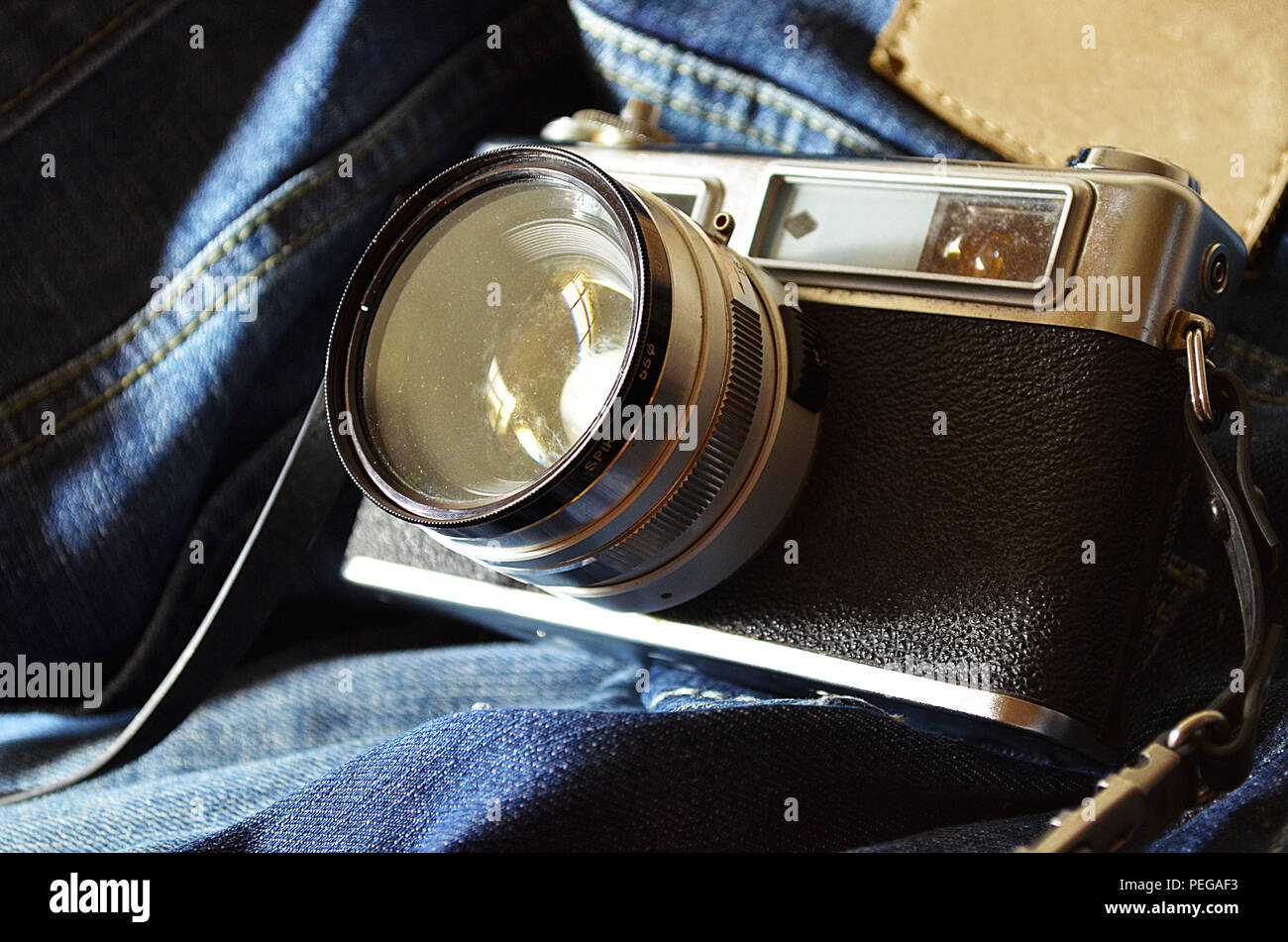 Traveller: Old SLR Camera and old jeans Stock Photo