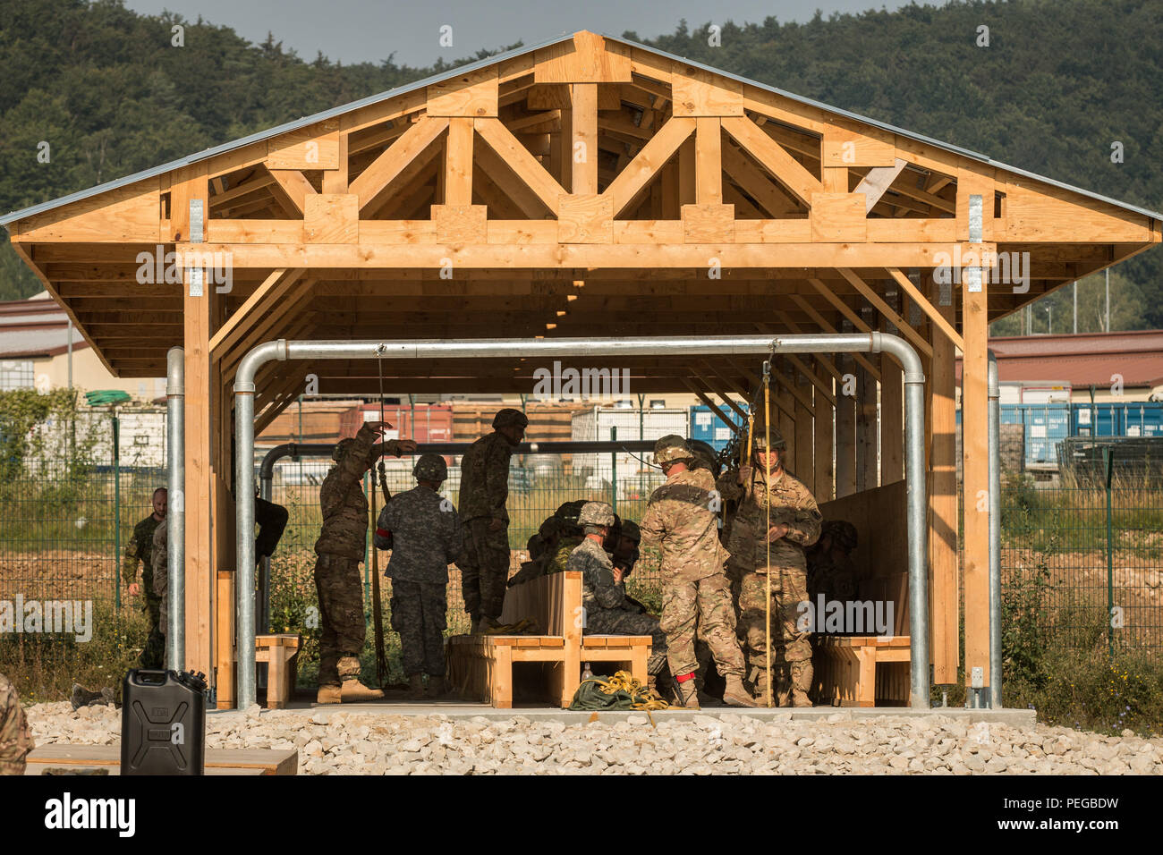 U.S. Soldiers conduct mock door procedure training in the newly built aircraft simulation building that Soldiers from the 465th Engineers (Vertical) from Birmingham, Alabama recently built. The building will allow airborne operations training during exercise Allied Spirit II and future exercises at the U.S. Army’s Joint Multinational Readiness Center in Hohenfels, Germany, Aug. 13, 2015. Allied Spirit II is a multinational decisive action training environment exercise that involves over 3,500 Soldiers from both the U.S., allied, and partner nations focused on building partnerships and interope Stock Photo